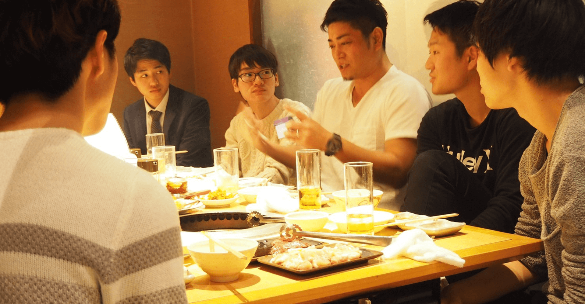 社長と学生が食事をしながら話す様子